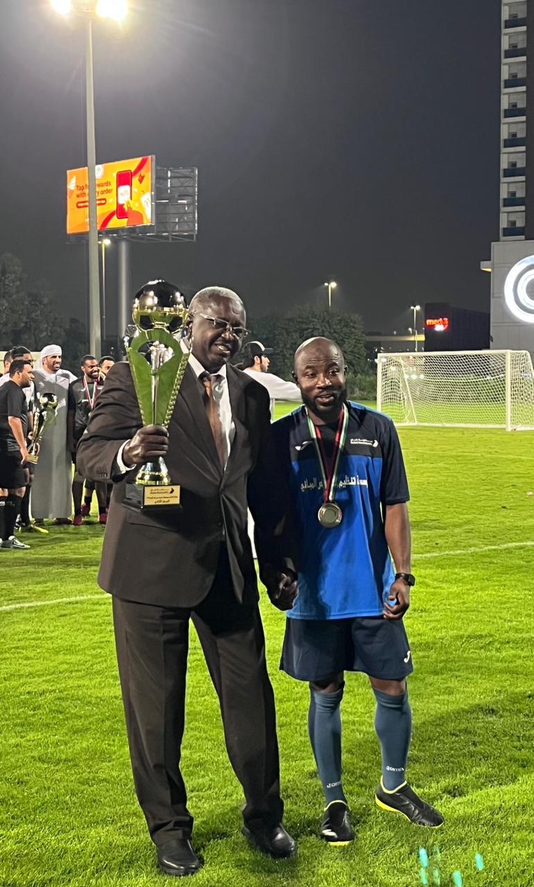 Maestro manager with a government official lifting a trophy